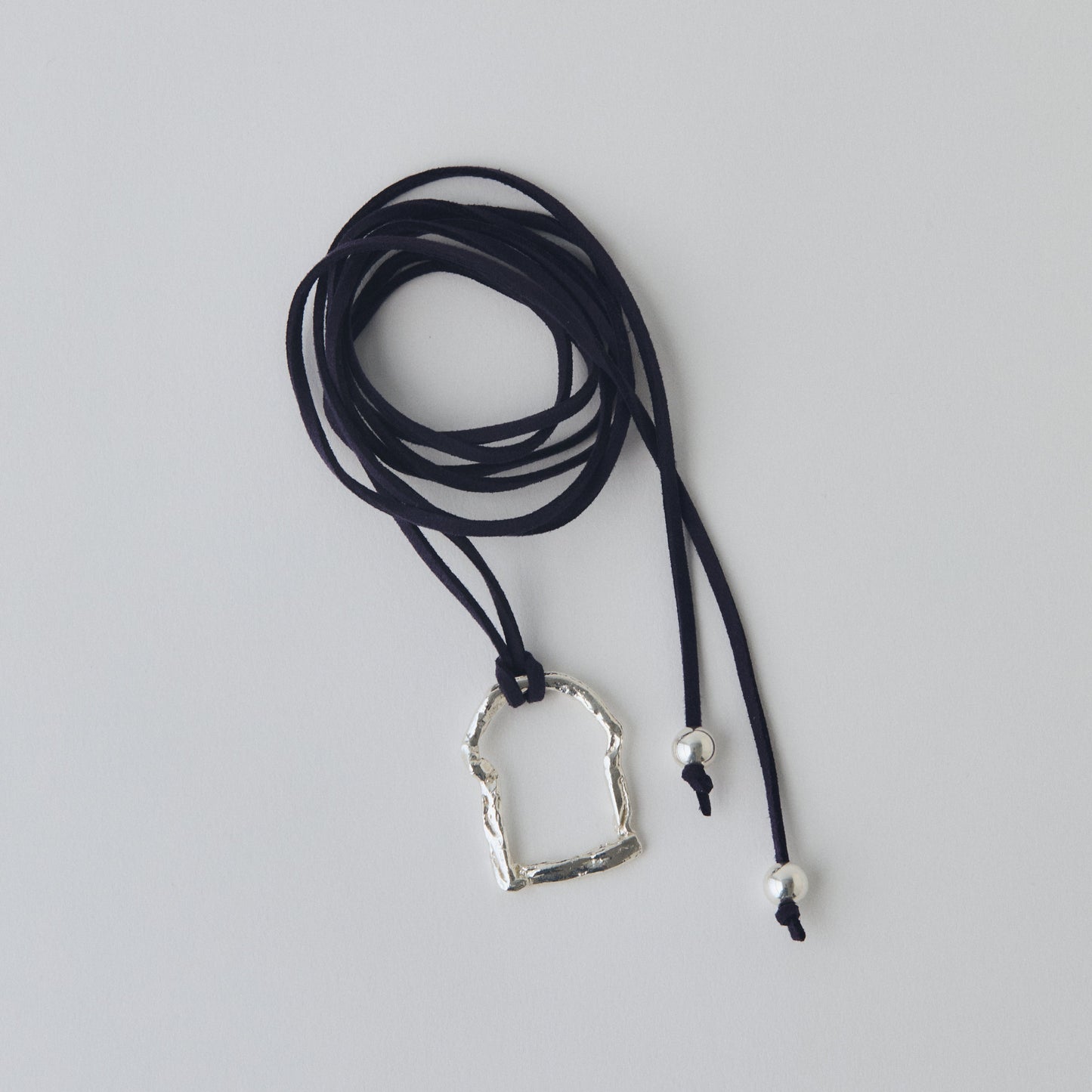 Necklace with a silver pendant on a gray background