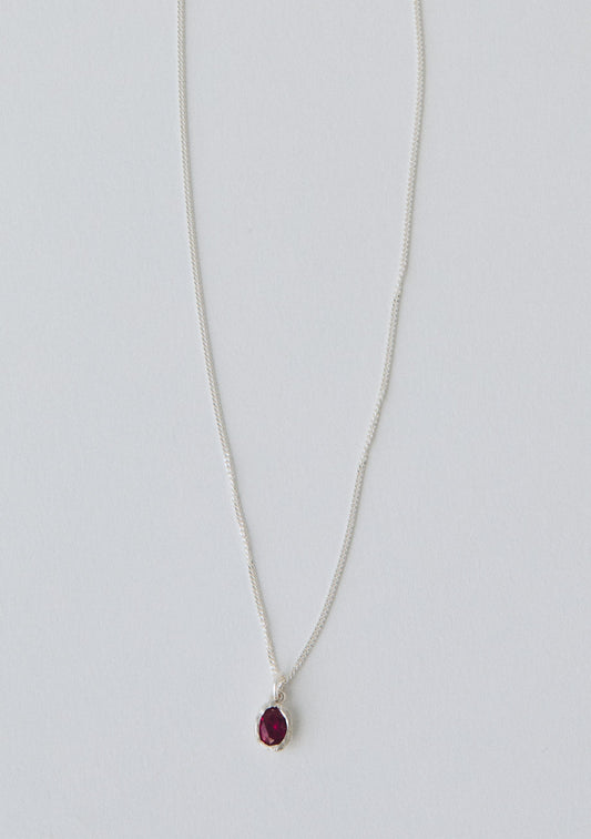 Necklace with a red pendant on a light gray background