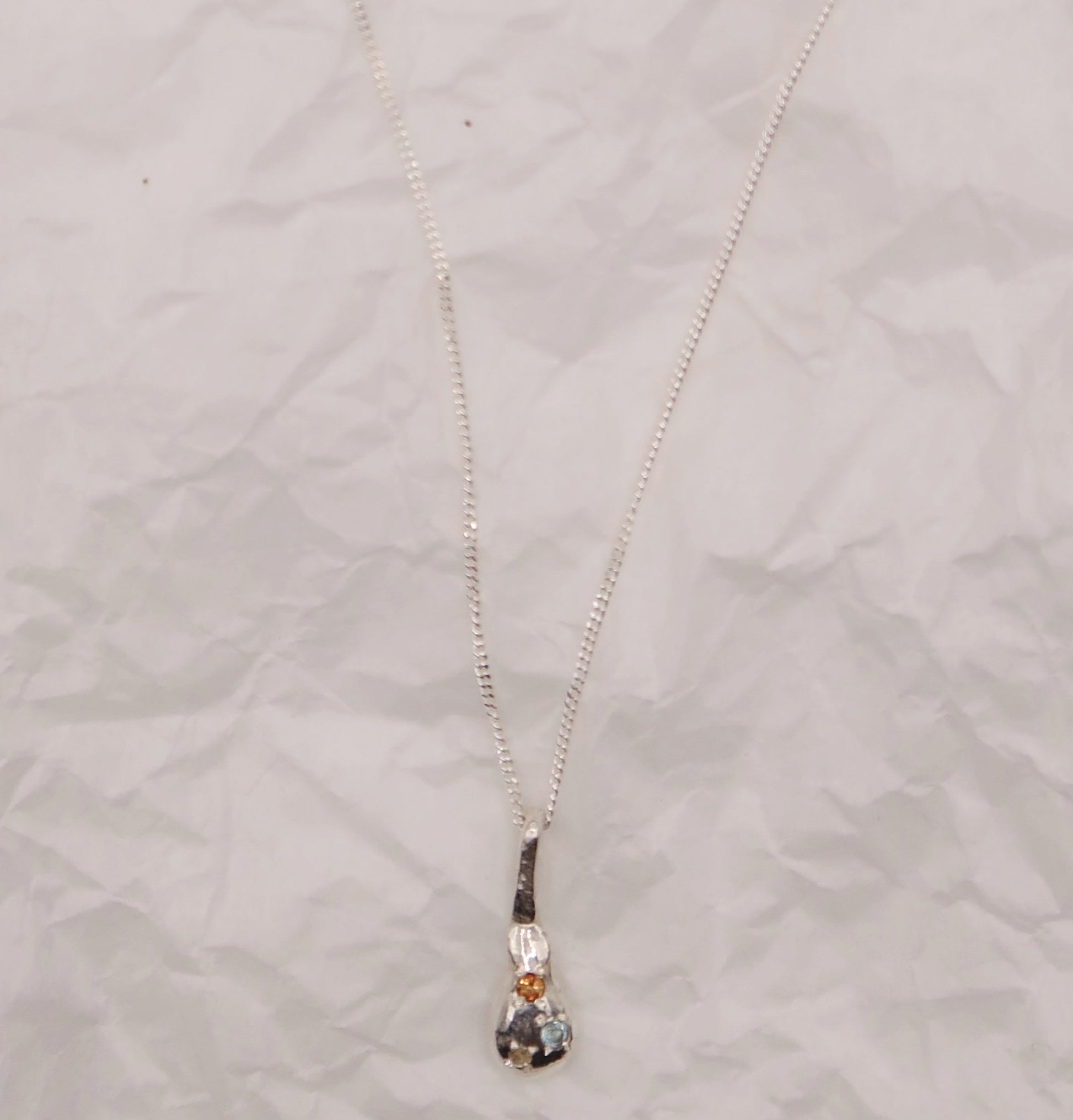 Necklace with a pendant on a textured light gray background