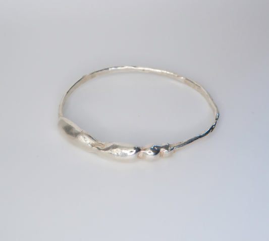 Silver bracelet on a light gray background