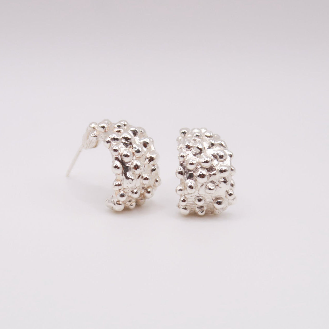 Pair of silver hoop earrings on a light gray background