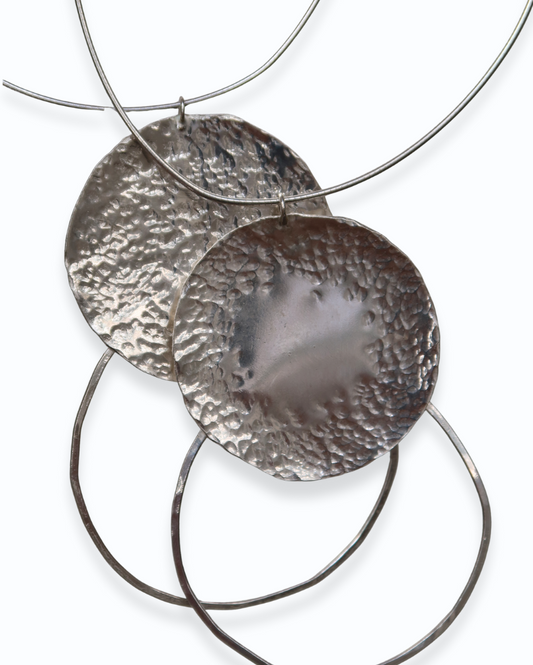 Silver circular pendant necklace on a white background