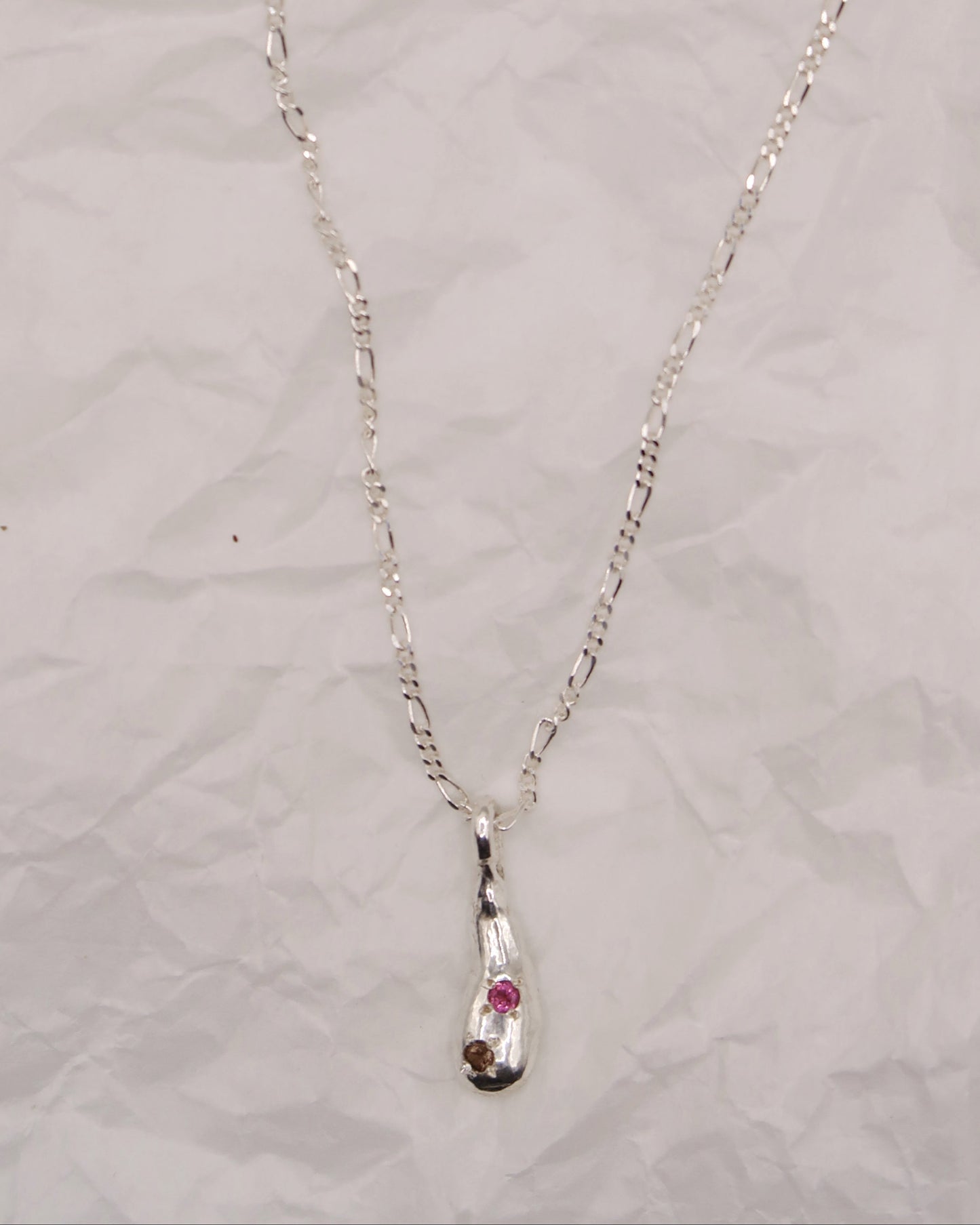 Silver necklace with an embedded pendant on a light gray background