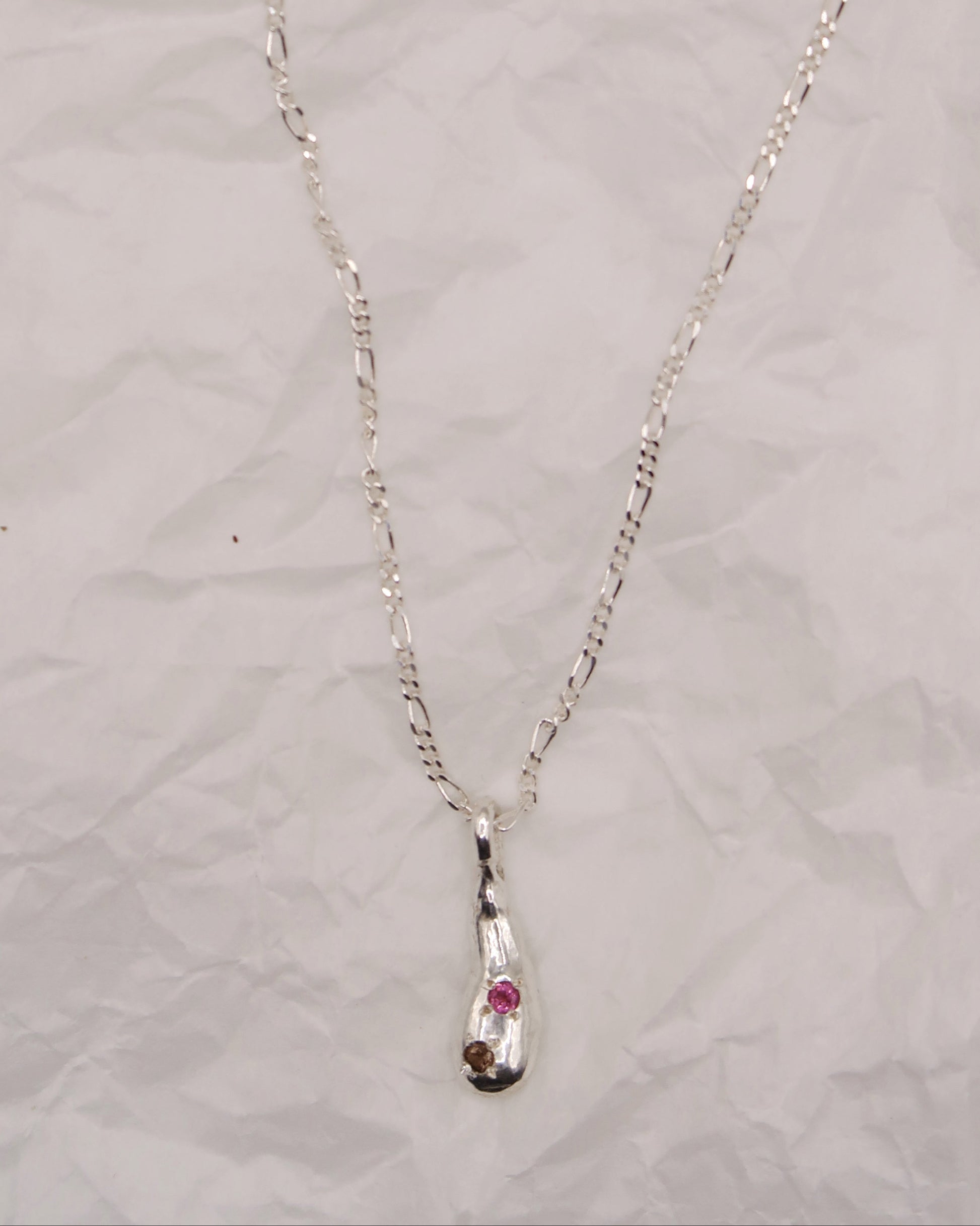 Silver necklace with an embedded pendant on a light gray background