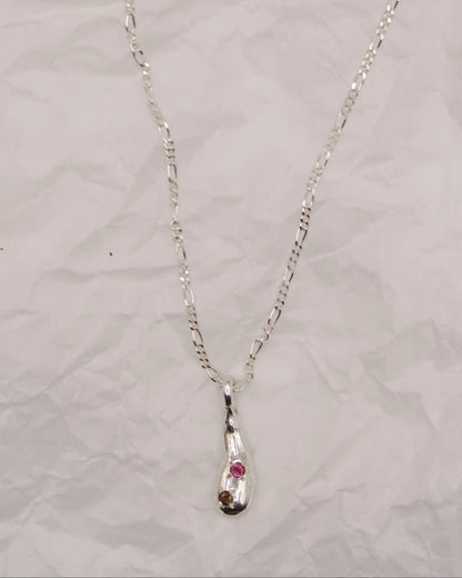 Silver necklace with an embedded pendant on a light gray background