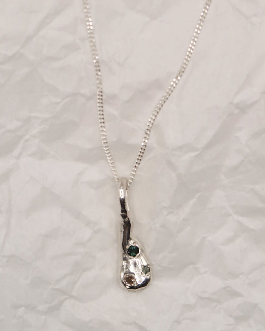 Silver necklace with a unique pendant on a textured white background