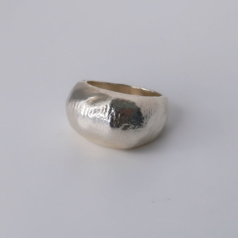 Silver ring with a textured surface on a light gray background