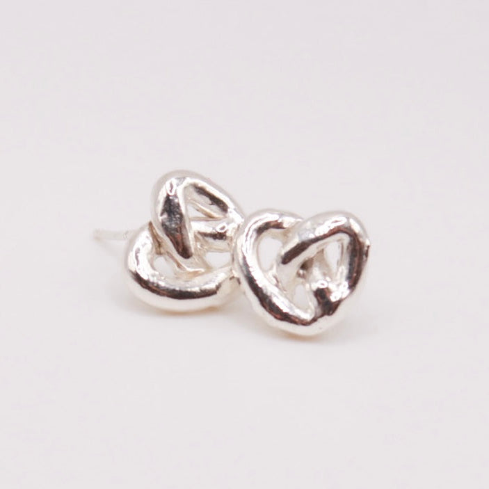 Pair of silver heart-shaped earrings on a light gray background