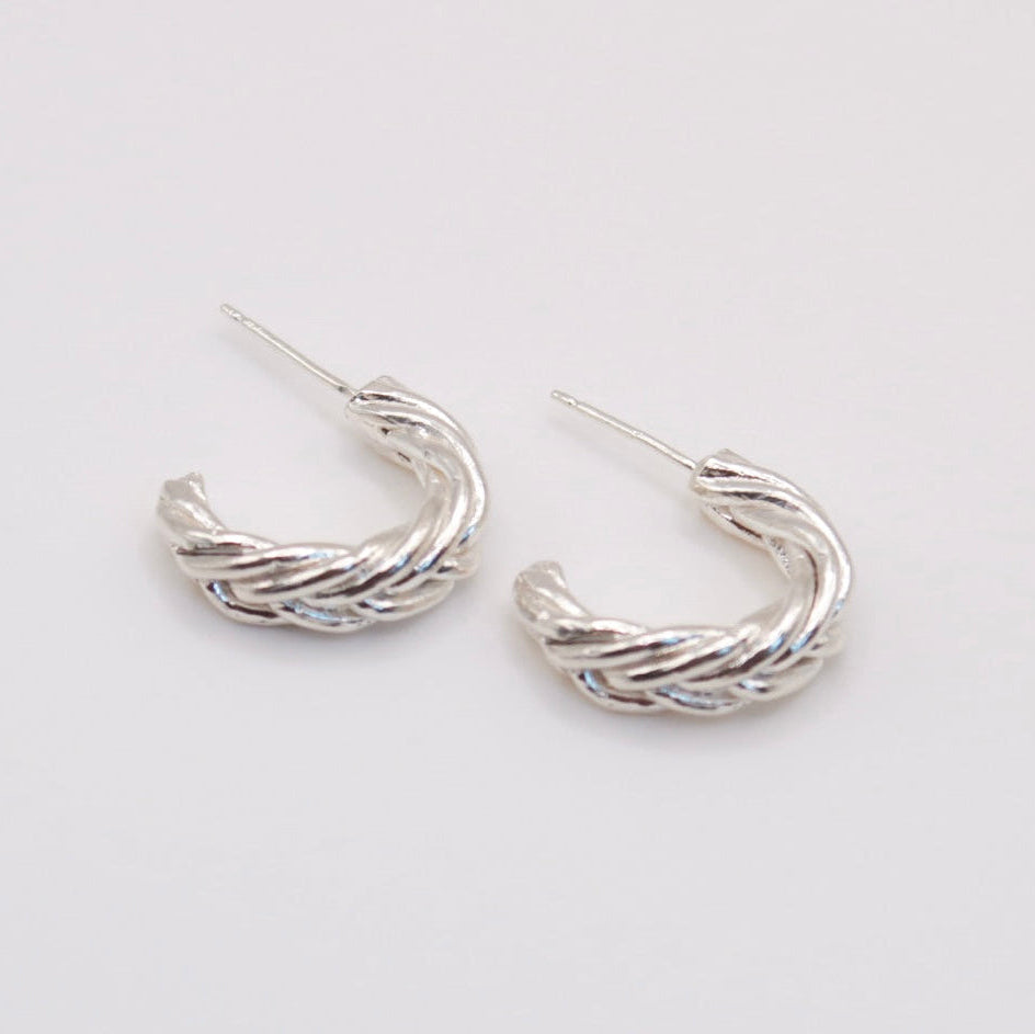Pair of silver hoop earrings on a light gray background