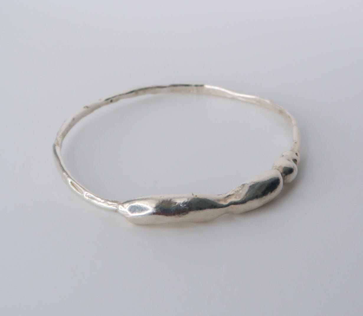 Silver bangle on a light gray background