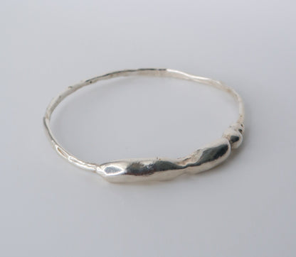 Silver bangle on a light gray background
