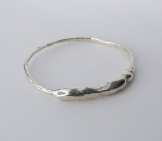 Silver bangle on a light gray background