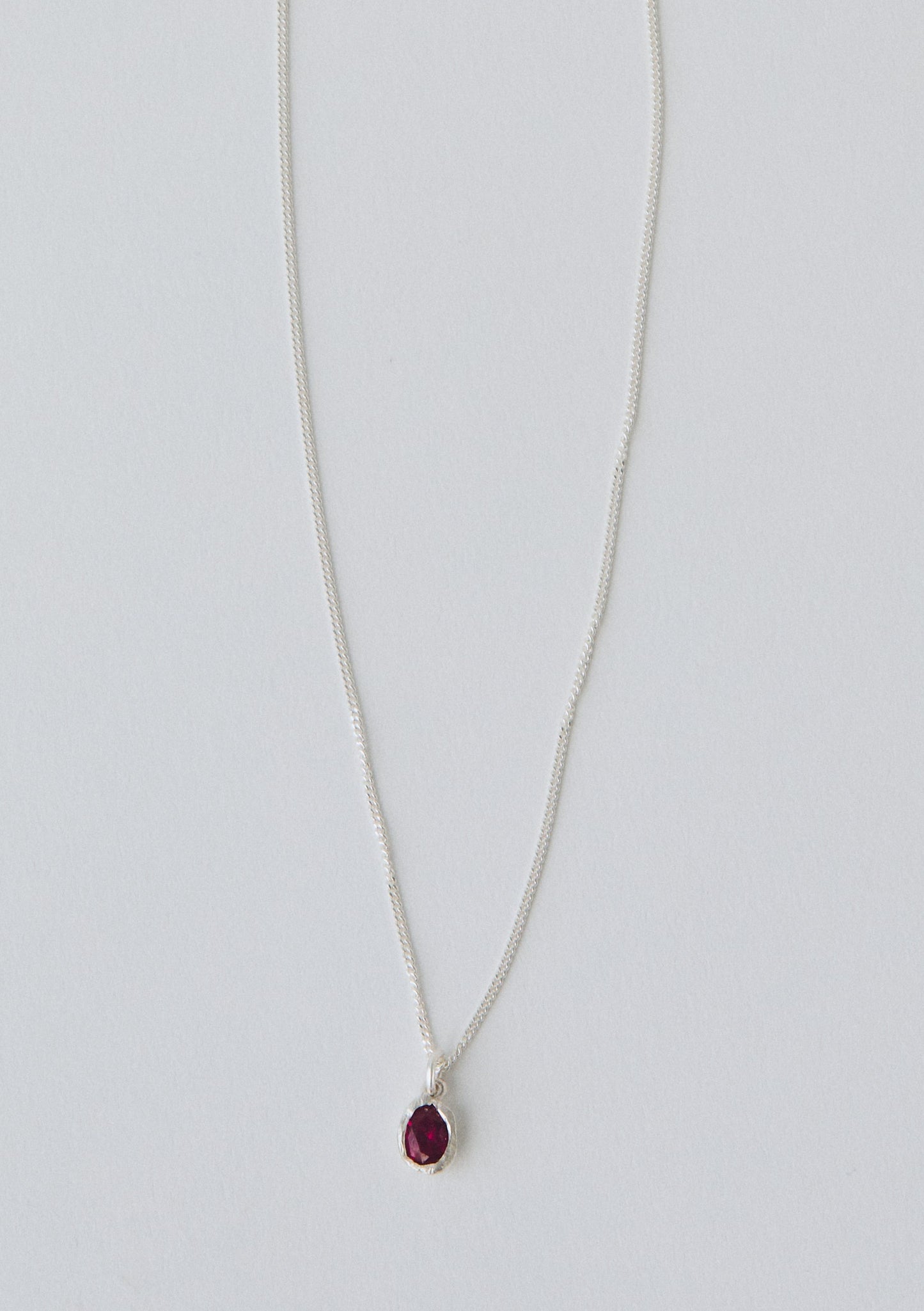 Necklace with a red pendant on a light gray background