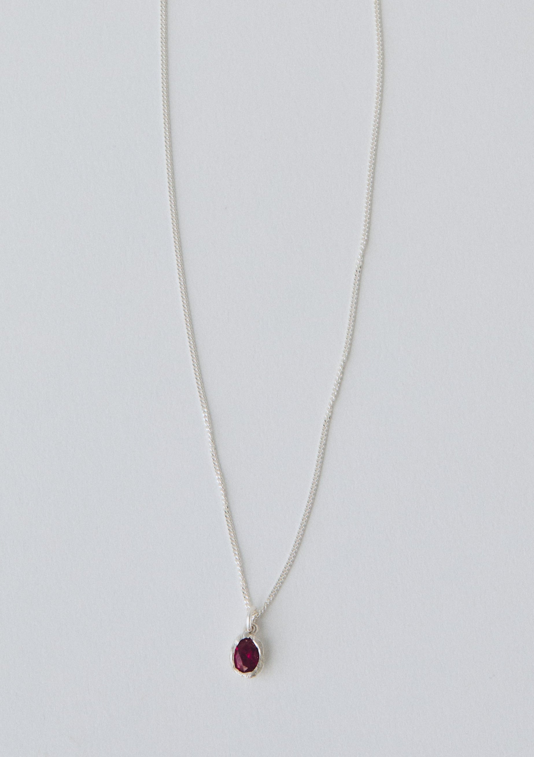 Necklace with a red pendant on a light gray background
