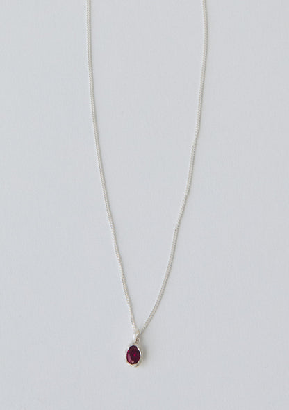 Necklace with a red pendant on a light gray background