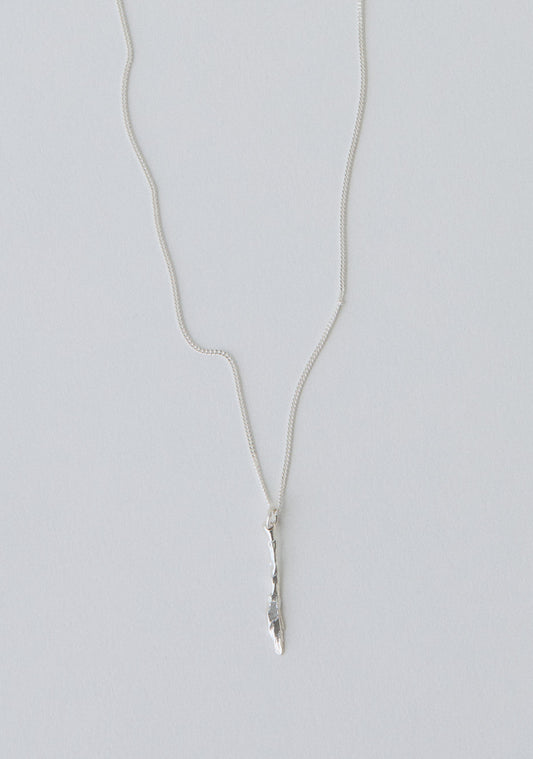 Silver necklace with a knife pendant on a light gray background