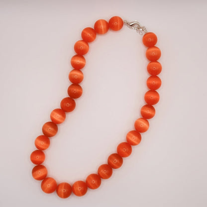 Necklace with orange beads on a white background