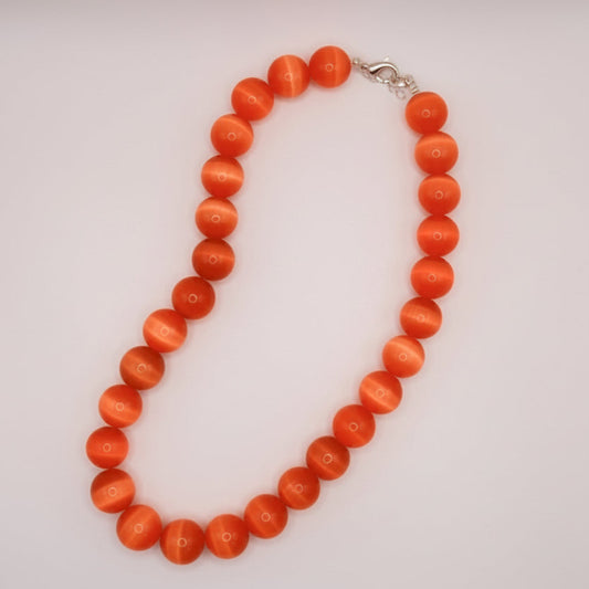 Necklace with orange beads on a white background